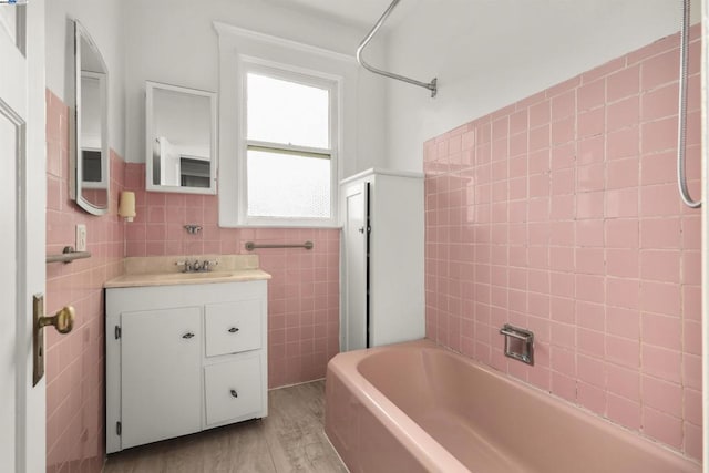 bathroom featuring tile walls, shower / bathing tub combination, vanity, and hardwood / wood-style flooring