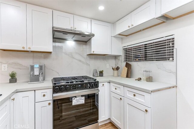 kitchen featuring white cabinets, backsplash, and black range with gas cooktop