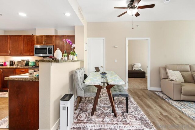 dining room with ceiling fan and light hardwood / wood-style flooring