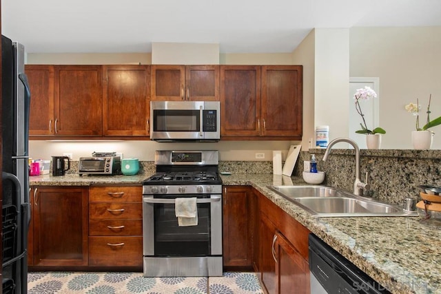 kitchen featuring light stone counters, sink, and appliances with stainless steel finishes