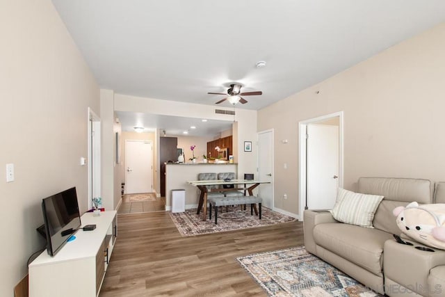 living room featuring ceiling fan and light hardwood / wood-style flooring