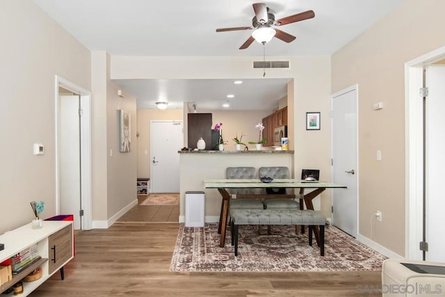 dining area with ceiling fan and light wood-type flooring