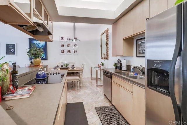 kitchen featuring stainless steel appliances, cream cabinetry, and sink