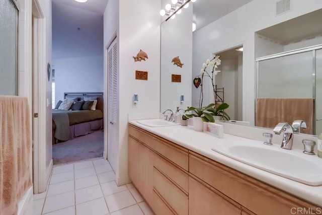 bathroom featuring tile patterned floors, an enclosed shower, and vanity