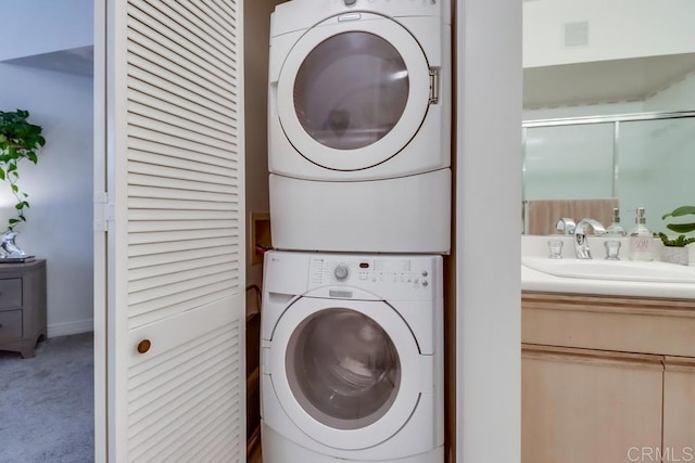 clothes washing area featuring stacked washer and clothes dryer, carpet floors, and sink