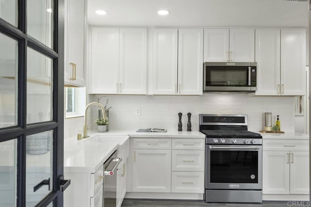 kitchen featuring backsplash, white cabinetry, and stainless steel appliances