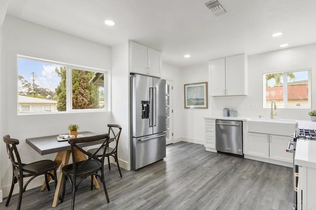 kitchen featuring sink, white cabinetry, hardwood / wood-style floors, and high quality appliances