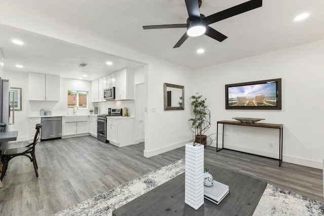 living room featuring ceiling fan, dark wood-type flooring, and sink