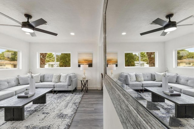 living room featuring dark wood-type flooring, plenty of natural light, and ceiling fan