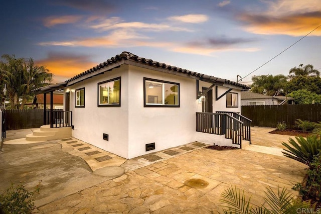 property exterior at dusk with a patio