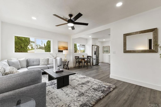 living room featuring ceiling fan and dark hardwood / wood-style flooring