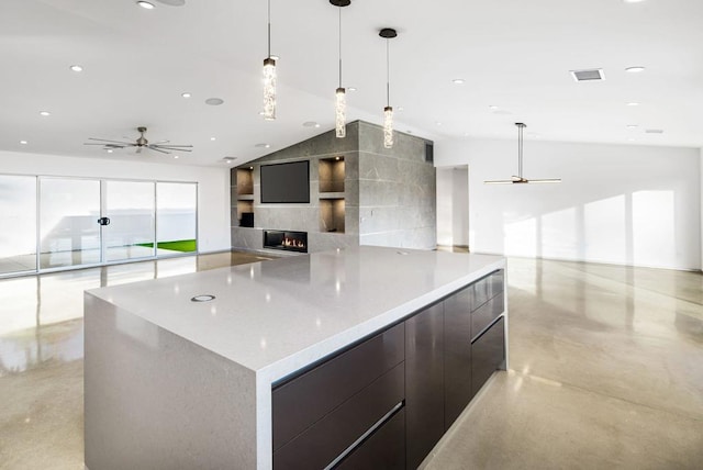 kitchen with hanging light fixtures, ceiling fan, and a large island