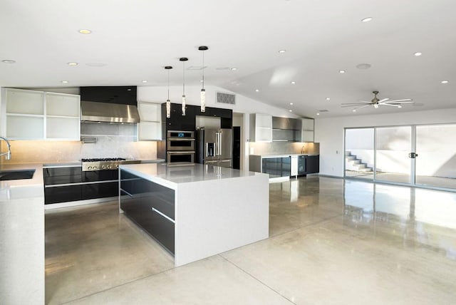 kitchen with decorative light fixtures, tasteful backsplash, wall chimney range hood, a spacious island, and appliances with stainless steel finishes