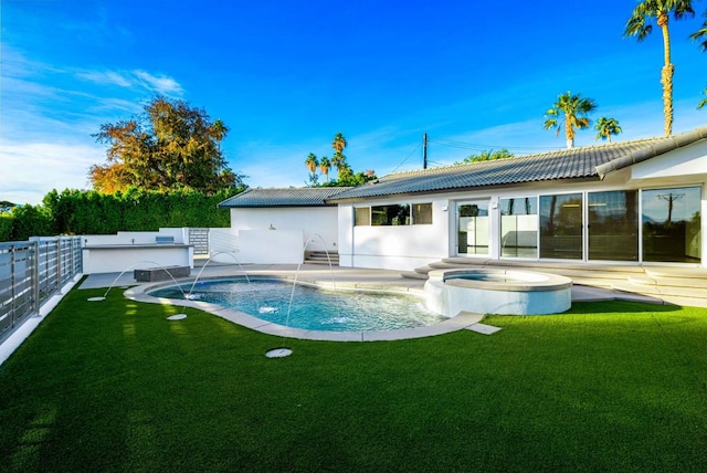 back of house with pool water feature, a swimming pool with hot tub, and a lawn