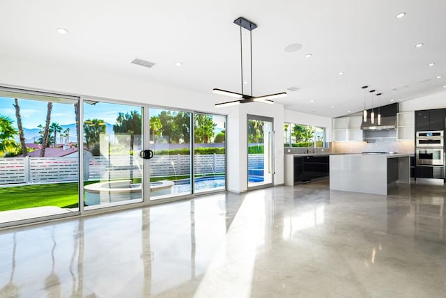 unfurnished living room featuring ceiling fan and sink