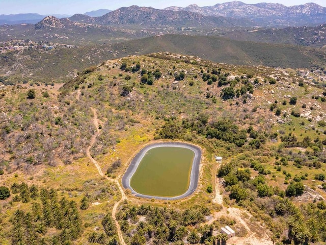 birds eye view of property with a water and mountain view