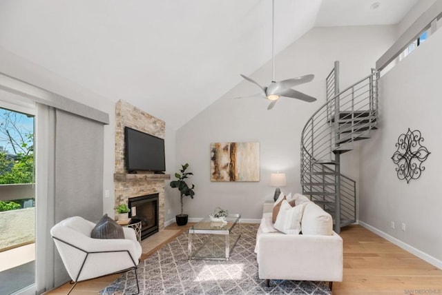 living room featuring lofted ceiling, a fireplace, a wealth of natural light, and hardwood / wood-style floors