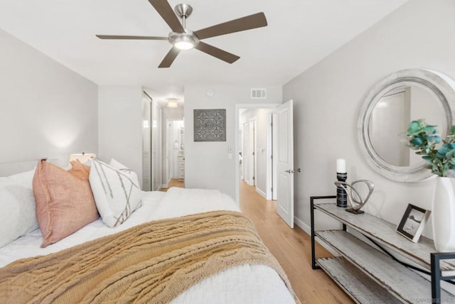 bedroom with ceiling fan, connected bathroom, and light hardwood / wood-style flooring