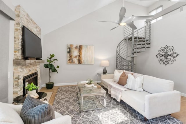 living room with vaulted ceiling, ceiling fan, a fireplace, and wood-type flooring