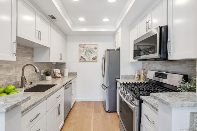 kitchen with light hardwood / wood-style floors, sink, white cabinetry, and stainless steel appliances