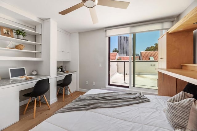 bedroom with ceiling fan, light hardwood / wood-style floors, and built in desk