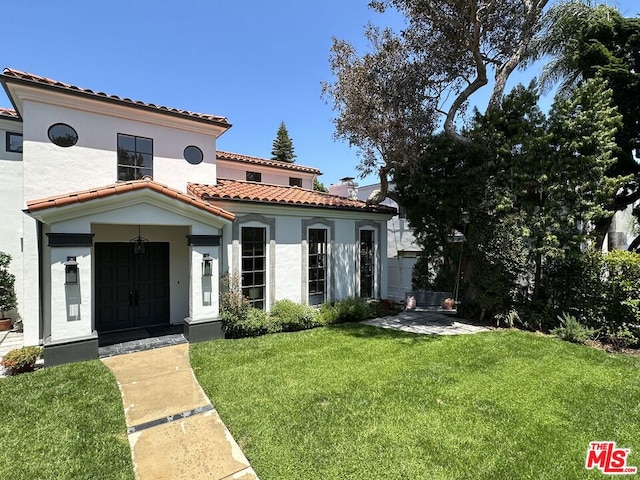 mediterranean / spanish home with a front lawn