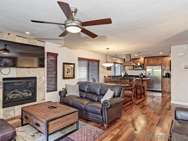 living room with dark wood-type flooring, sink, and a tiled fireplace