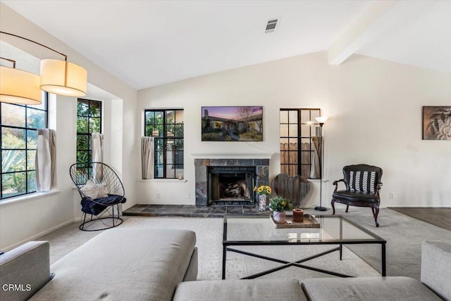 carpeted living room with vaulted ceiling with beams and a fireplace