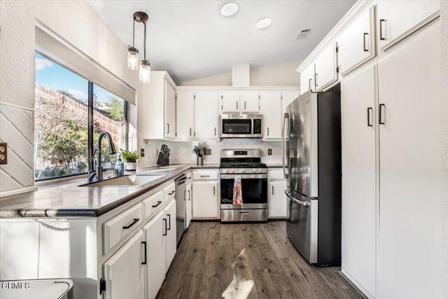 kitchen featuring hanging light fixtures, white cabinets, sink, and stainless steel appliances