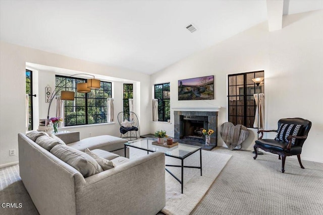 carpeted living room with a tile fireplace and lofted ceiling