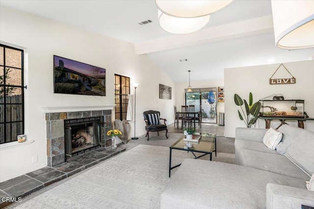 carpeted living room featuring vaulted ceiling with beams and a fireplace