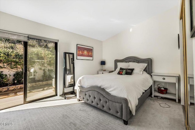 bedroom with lofted ceiling, carpet, and access to exterior