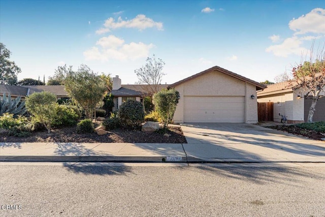 view of front of home with a garage, concrete driveway, a chimney, and stucco siding