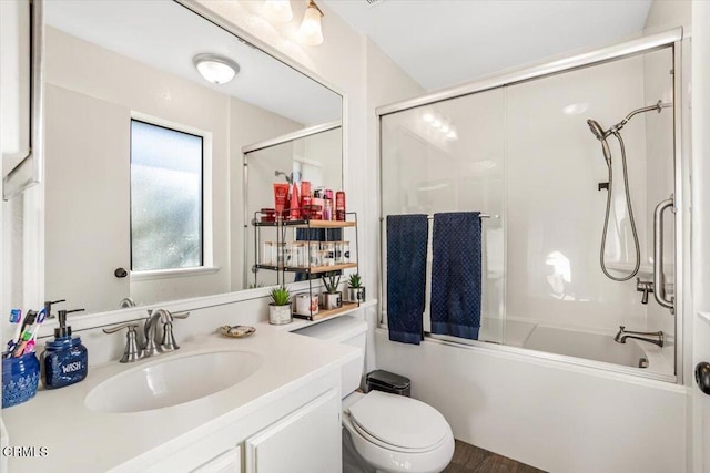 full bath featuring toilet, combined bath / shower with glass door, and vanity