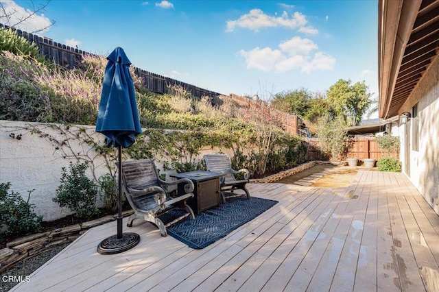 wooden deck with a fenced backyard