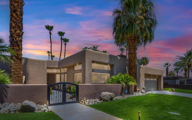 southwest-style home with a garage and a lawn