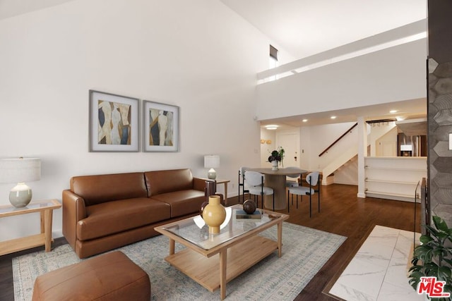 living room featuring a high ceiling and dark hardwood / wood-style flooring