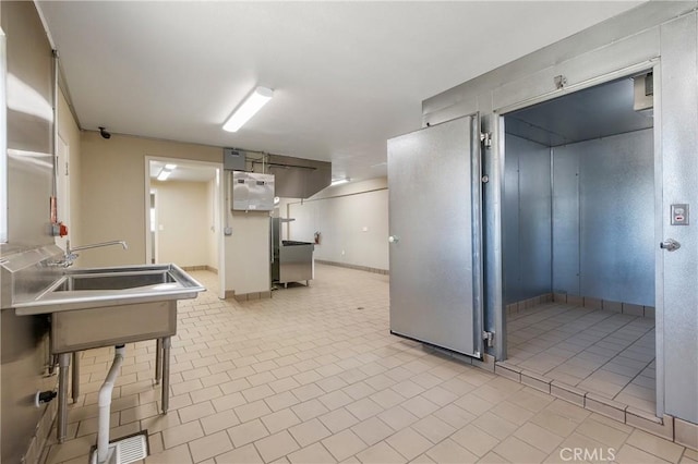 kitchen featuring a breakfast bar, sink, and light tile patterned floors