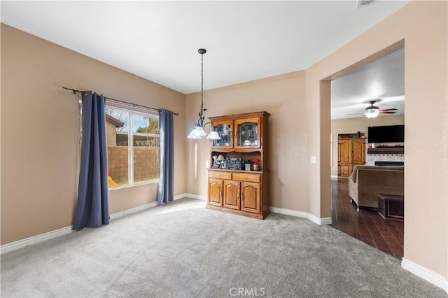 carpeted dining room featuring ceiling fan