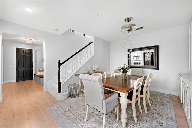 dining room with light hardwood / wood-style floors and an inviting chandelier