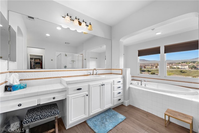 bathroom featuring vanity, wood-type flooring, and independent shower and bath