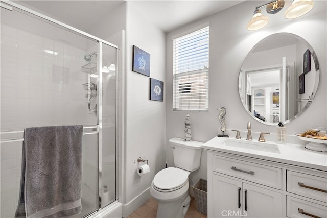 bathroom with toilet, a shower with shower door, and vanity