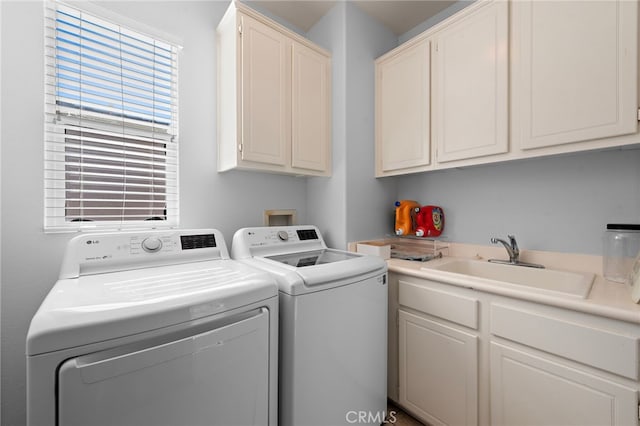 clothes washing area featuring cabinets, washer and clothes dryer, and sink