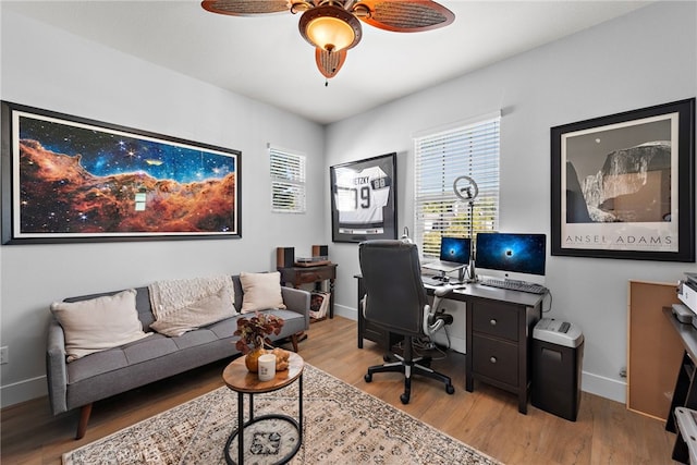 home office with light wood-type flooring and ceiling fan