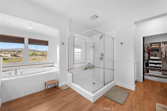 bathroom with shower with separate bathtub and hardwood / wood-style floors