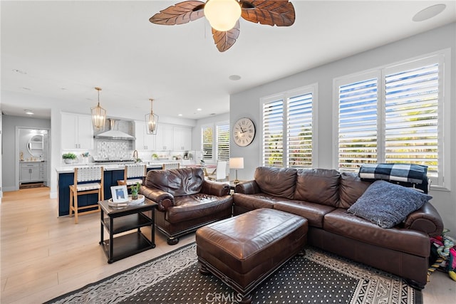 living room featuring ceiling fan and light hardwood / wood-style flooring