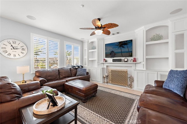 living room with ceiling fan and built in shelves