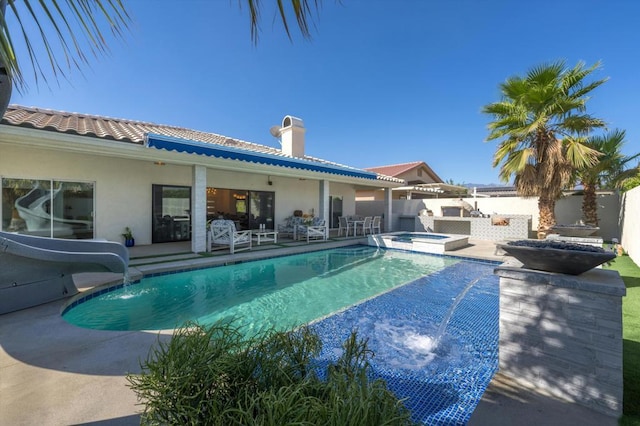 view of swimming pool featuring an in ground hot tub, a water slide, and a patio