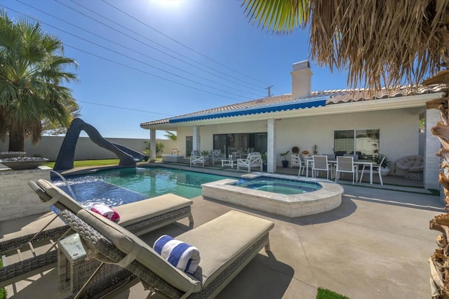 view of pool with an in ground hot tub, a water slide, and a patio