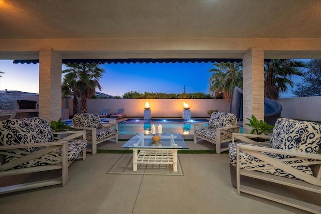 patio terrace at dusk with outdoor lounge area and a fenced in pool